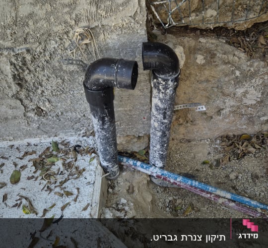 צינורות פלסטיק שחורים מותקנים בקיר בטון